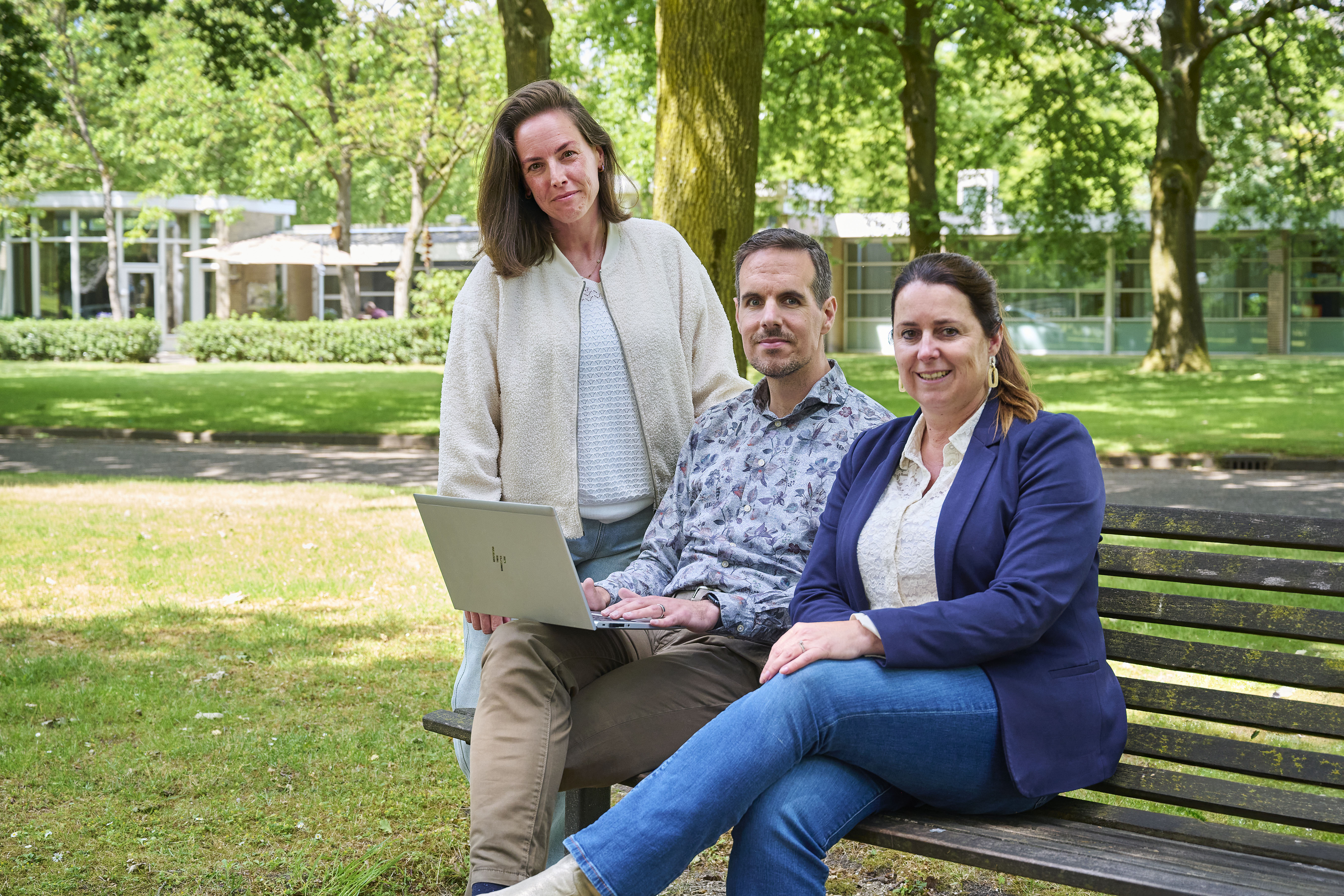 Kim Wentink (links), Boudewijn Bus en Hanneke Manders van het Expertisecentrum Hersenletsel en Neuropsychiatrie. Op de achtergrond de woningen waar mensen met hersenletsel verblijven. © Jeroen Appels/Van Assendelft